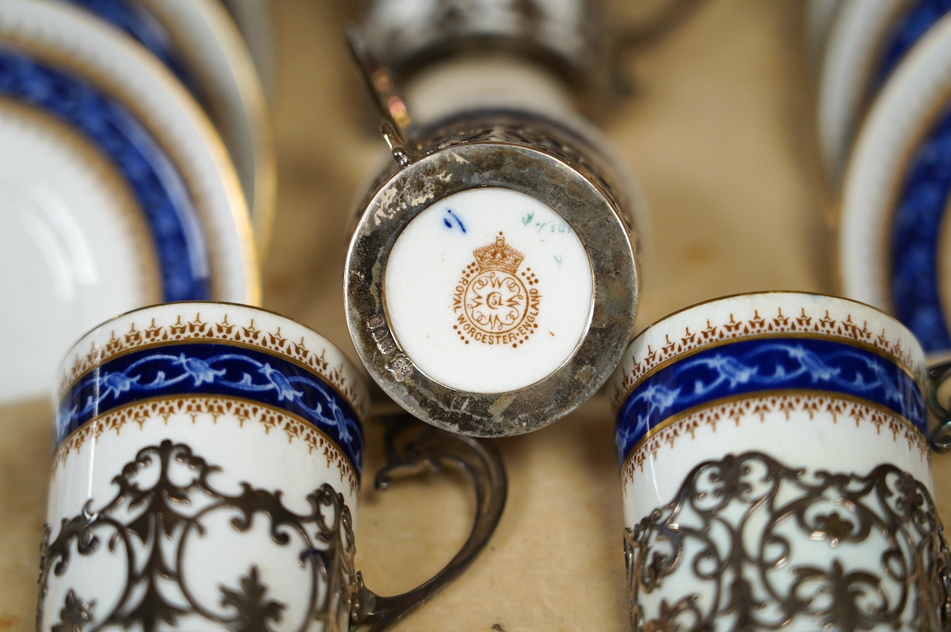 A cased Worcester coffee set with silver coffee can holders, saucers 11.5cm in diameter. Condition - fair, some cracks and crazing